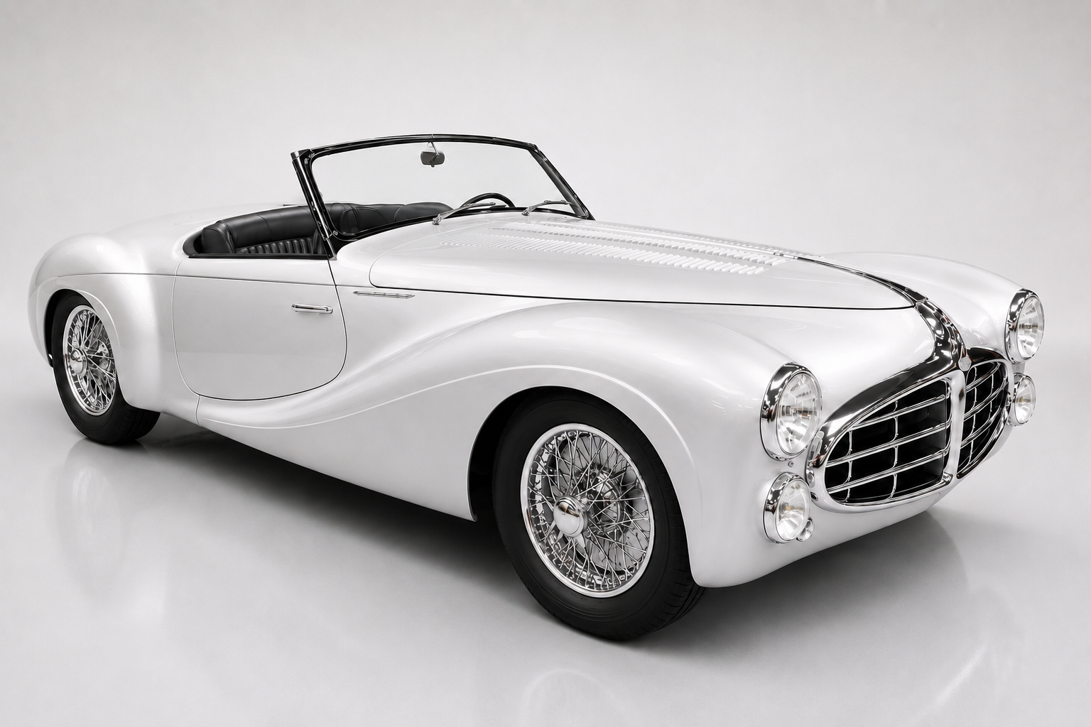 White Delahaye Type 235 roadster, front three-quarter studio view, showing full-width ponton bodywork, the chrome grille, wire wheels and a low-cut windscreen.