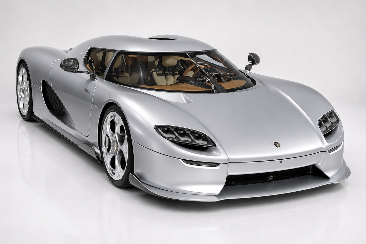Silver Koenigsegg CC850 in a bright studio, front three-quarter view showing the removable roof, dihedral synchro-helix doors, tan leather interior visible through the wraparound glass, sculpted front nose with LED lighting, deep front splitter and polished multi-spoke alloy wheels — the analog homage to the CC8S.