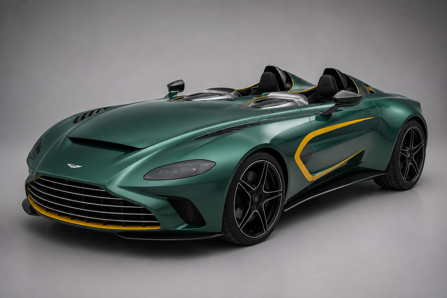 Metallic green Aston Martin V12 Speedster with yellow accent stripes, front three-quarter studio view on a grey backdrop showing the roofless, screenless open cockpit, twin carbon-fibre headrest fairings, large front grille and multi-spoke black alloy wheels.