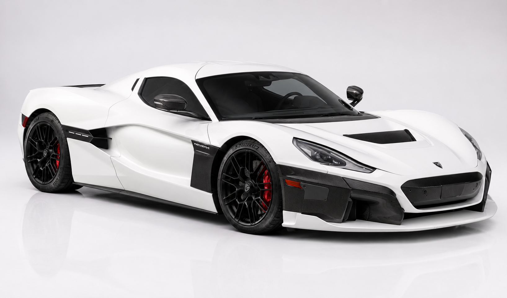 White Rimac Nevera electric hypercar in a studio setting, front three-quarter view showing the low mid-engine silhouette, carbon-fibre front splitter and side vents, black lightweight wheels with red brake calipers and body-colour bonnet with Nevera script.