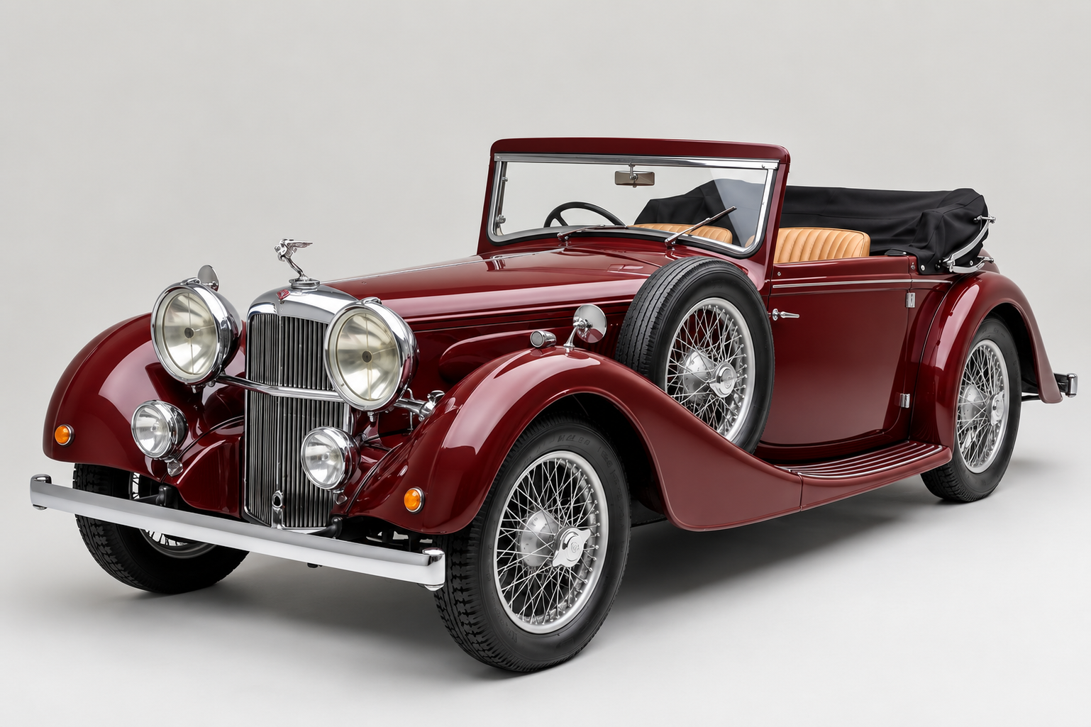 Maroon Alvis 4.3-Litre drophead coupé with the hood folded, front three-quarter view in a studio, showing the tall chrome radiator with eagle mascot, four chrome-ringed lamps, side-mounted spare wheel and centre-lock wire wheels.