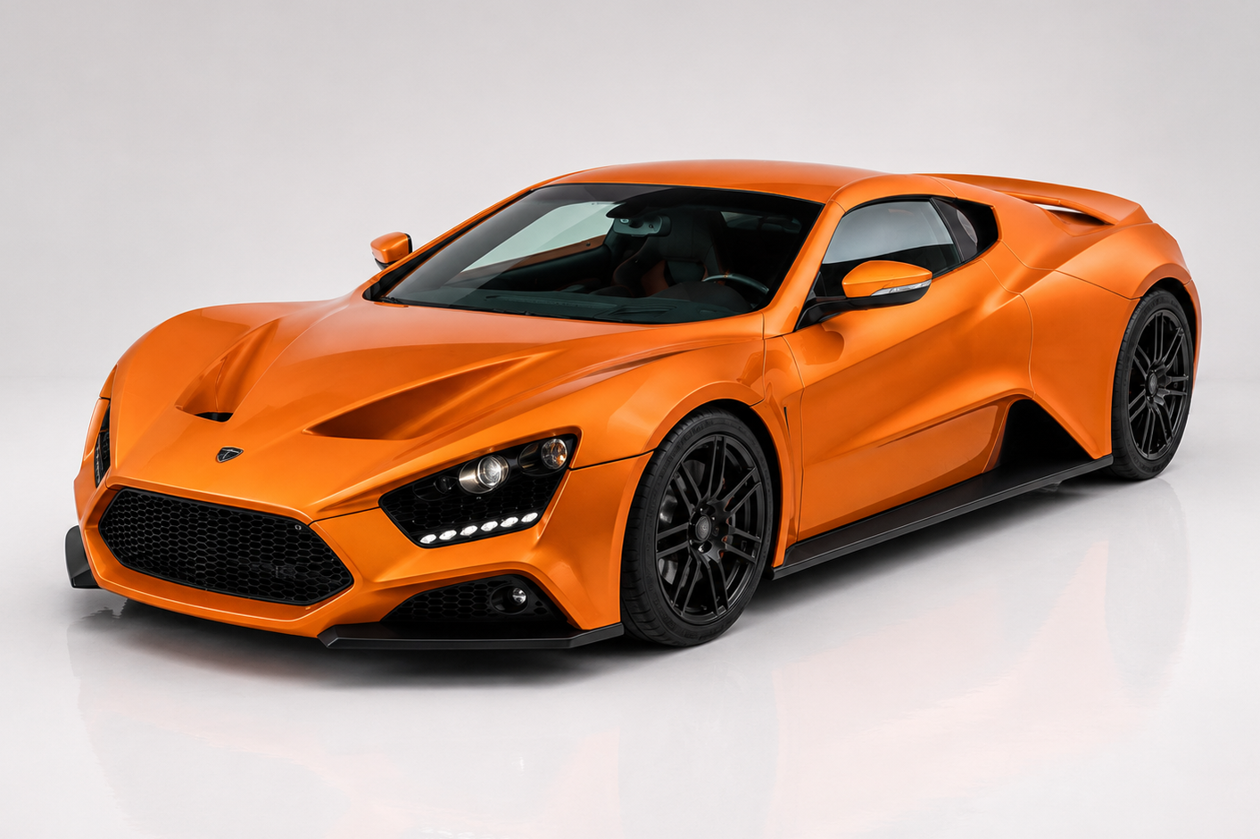 Zenvo ST1 in signature Zenvo Orange under studio lighting, showing the mid-engined two-seat coupé silhouette, deep front intake, side sill air-management, dark five-spoke forged wheels and the exposed carbon-fibre lower panels — the definitive presentation of Denmark's first hand-built hypercar.