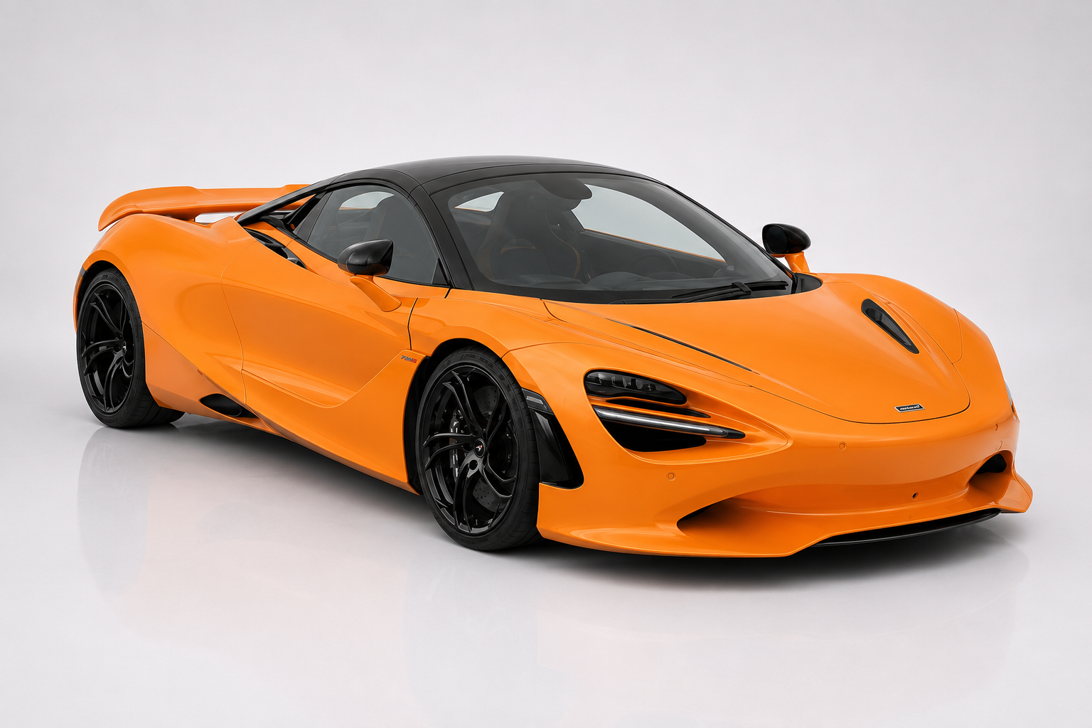 Orange McLaren 750S in a studio setting, front three-quarter view showing the aggressive front splitter and side inlets, black lightweight wheels, prominent rear wing and MonoCage II carbon structure — the sharpened evolution of the 720S and McLaren's combustion Super Series send-off.