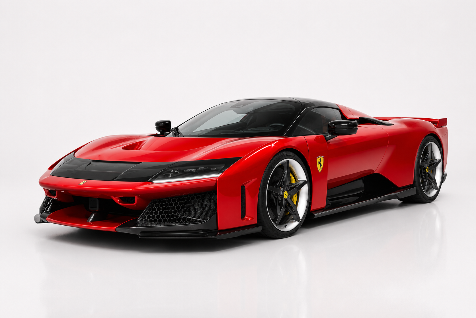 Red Ferrari F80 photographed in a studio, front three-quarter view showing the aerospace-inspired nose, black centre bonnet section, front splitter, black wing mirrors and dark five-spoke wheels with yellow brake calipers.