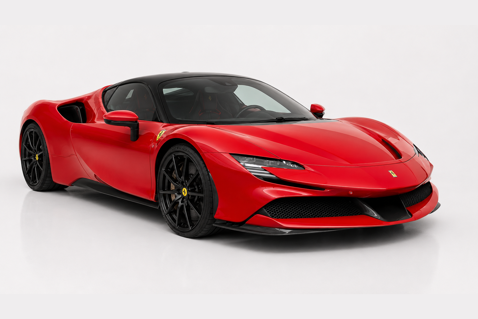 Red Ferrari SF90 Stradale photographed in a studio, front three-quarter view showing the low nose with slim headlamps, aggressive front splitter with black aero elements, deep side intakes and multi-spoke black alloy wheels.