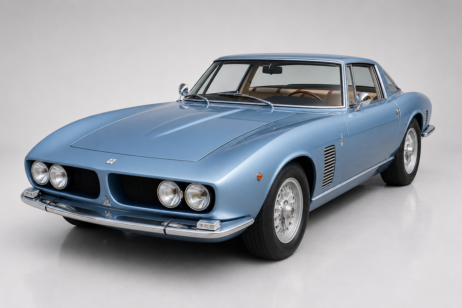 Light blue Iso Grifo in a bright studio, front three-quarter view showing Giugiaro's low bonnet with quad round headlights, slim chrome bumper, side gill vent behind the front wheel, chrome wire wheels and pale interior — the Bertone-styled Bizzarrini-engineered Chevy V8 GT.