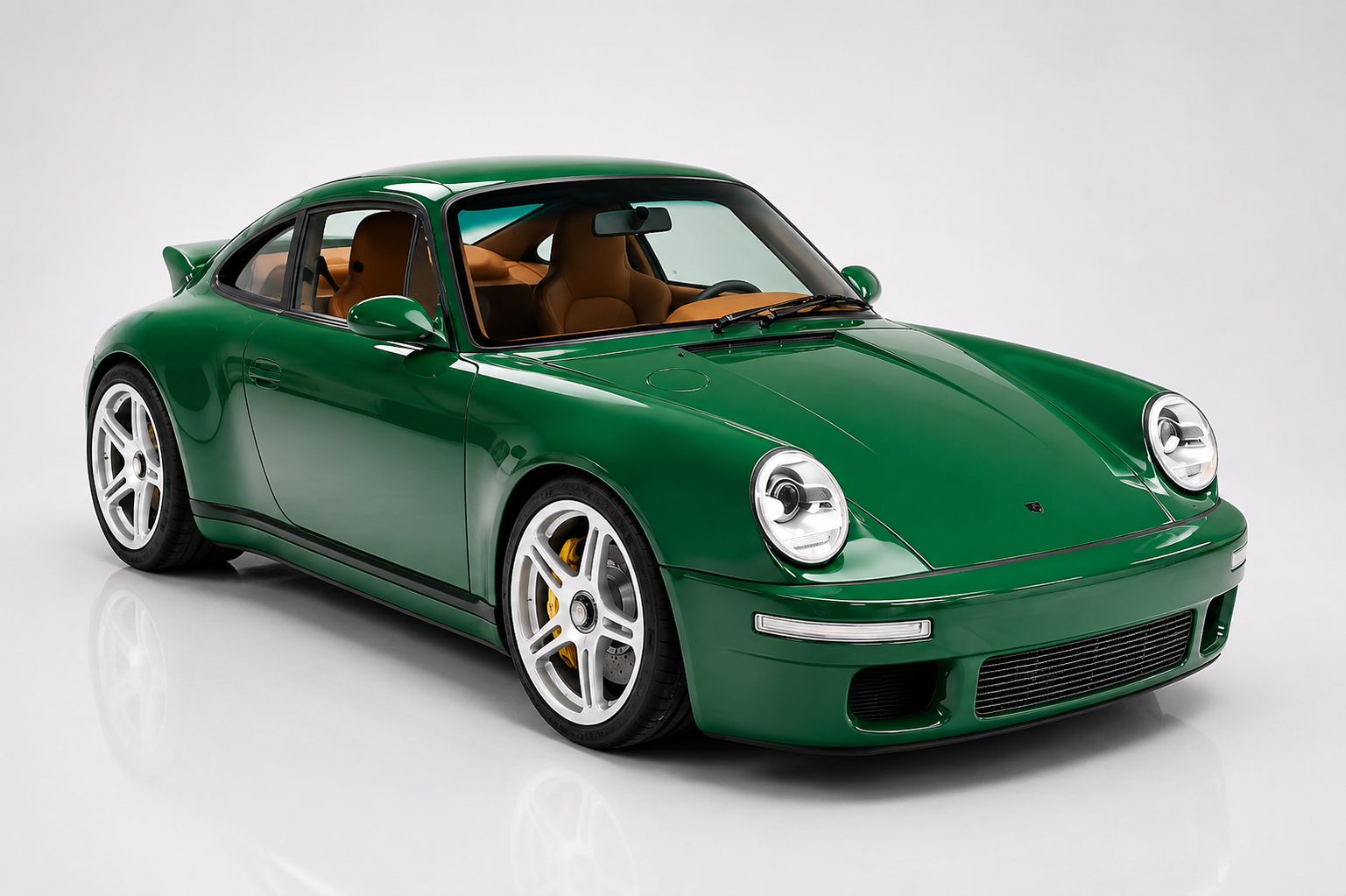 British-racing-green RUF SCR in a studio setting, front three-quarter view showing the classic narrow-body 911 silhouette with round headlamps, chin splitter, integrated fog lamps, five-spoke silver wheels with yellow calipers and body-colour side sills — the modern naturally aspirated bespoke RUF on its own carbon monocoque.