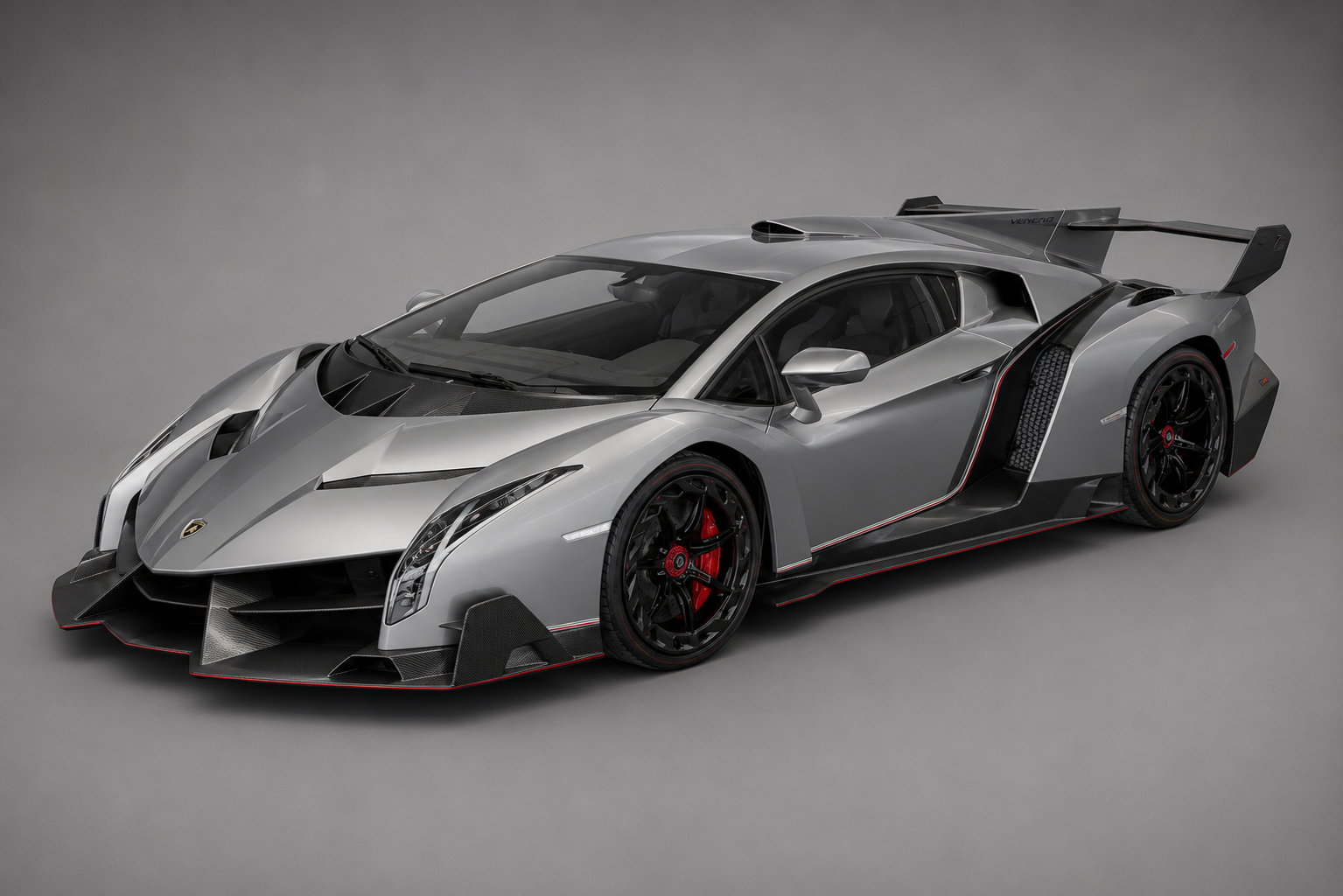 Silver Lamborghini Veneno coupe in a studio setting, front three-quarter view showing the sharp angular carbon-fibre bodywork, aggressive front splitter with red accents, exposed carbon side skirts, large rear wing and black multi-spoke wheels with red brake calipers.