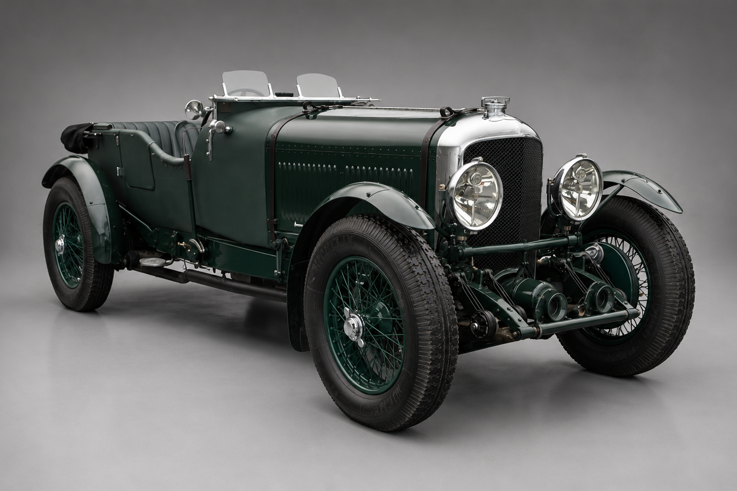 British racing green Bentley Speed Six open tourer photographed front three-quarter in a studio, showing the exposed radiator and mesh grille, twin aero screens, side-mounted headlamps and wire wheels.