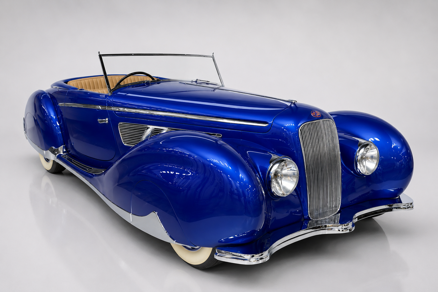 Blue Delage D8-120 aerodynamic roadster, front three-quarter studio view, showing skirted pontoon wings, external side exhausts, whitewall tyres and right-hand-drive cockpit.