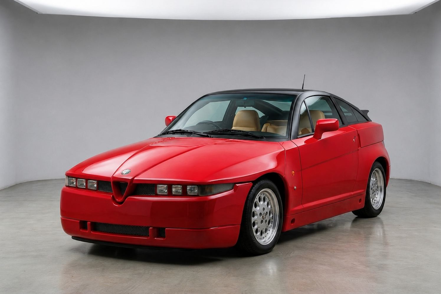 Red Alfa Romeo SZ (ES-30) coupe with black roof and tan interior, front three-quarter studio view, showing its wedge Zagato bodywork, six-lamp nose and alloy wheels.