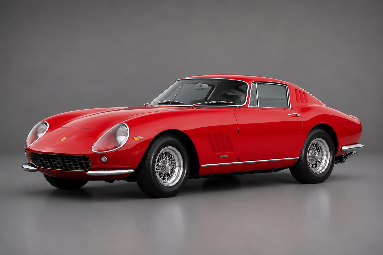 Red Ferrari 275 GTB coupe, front three-quarter studio view on a plain grey backdrop showing the long bonnet, side vents and wire wheels.
