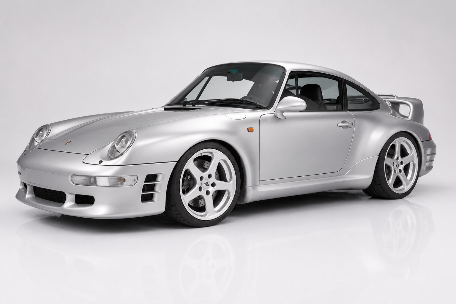 Silver RUF CTR2 in a studio setting, front three-quarter view showing the 993-generation 911 silhouette with RUF-specific front bumper and side inlets, RUF five-spoke wheels and integrated rear spoiler — the twin-turbocharged 993-based successor to the Yellowbird.