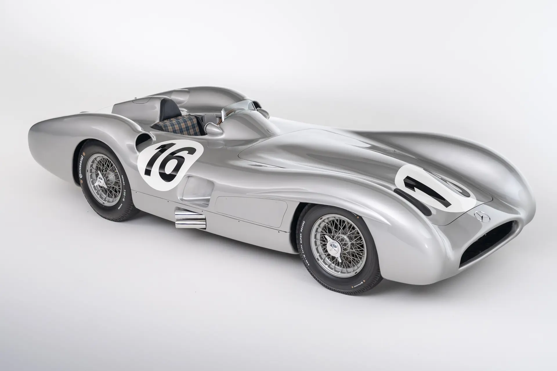 Silver Mercedes-Benz W196 R Stromlinienwagen streamliner, race number 16, photographed in a studio, front three-quarter view showing the fully enclosed-fender bodywork.