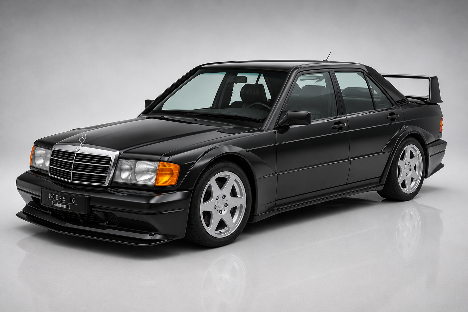 Black Mercedes-Benz 190E 2.5-16 Evolution II in a studio setting, front three-quarter view showing the iconic DTM homologation body kit, large adjustable rear wing, flared wheel arches, deep front splitter, monoblock alloy wheels and the signature Blue-Black metallic finish.
