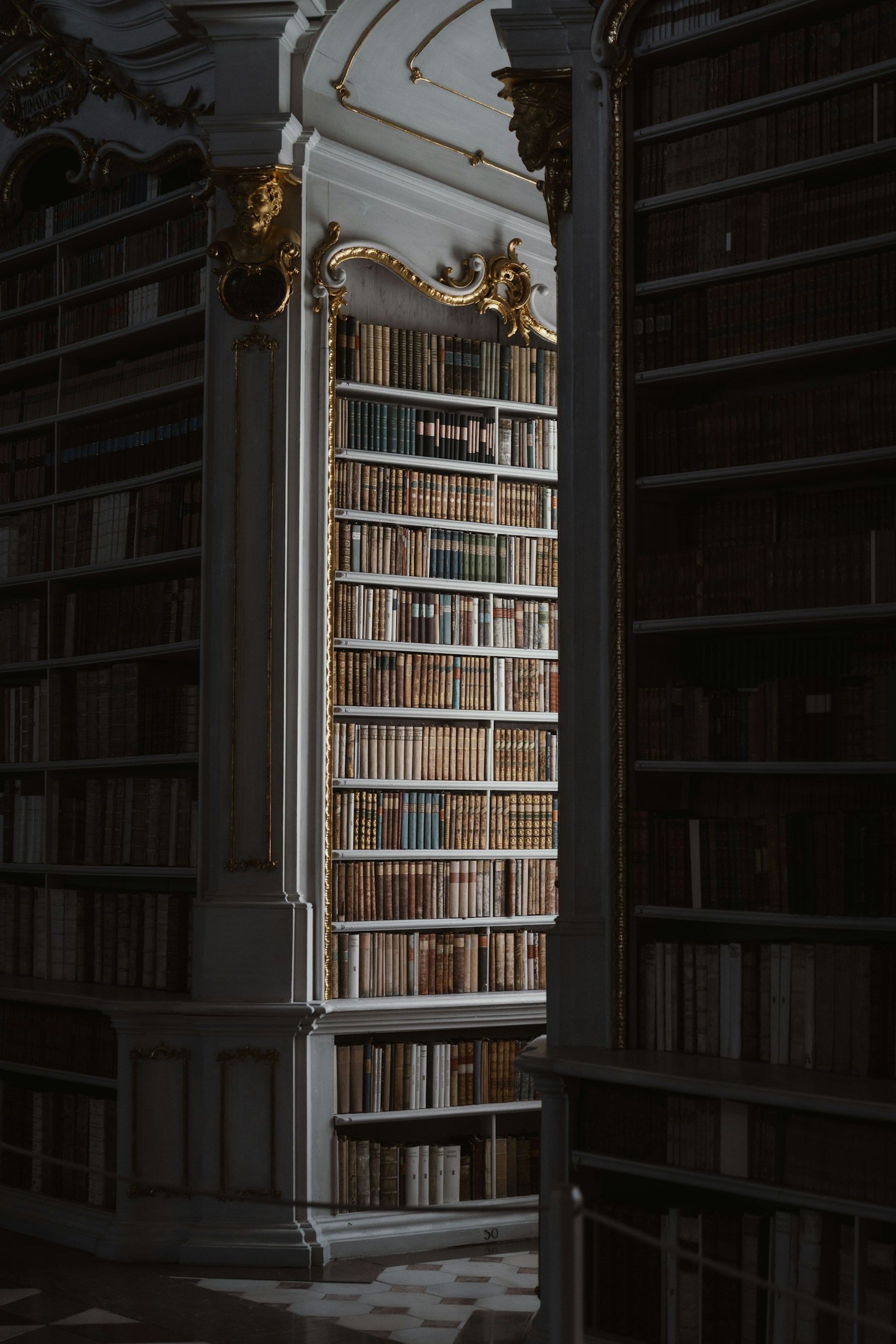A wood-panelled library archive room with leather-bound automotive reference books and a brass desk lamp.