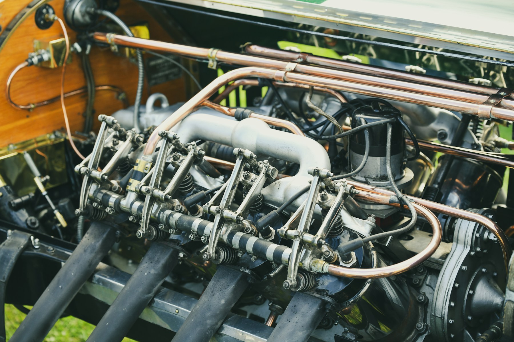 A restorer's hands polishing a chromed vintage carburettor under warm workshop light.