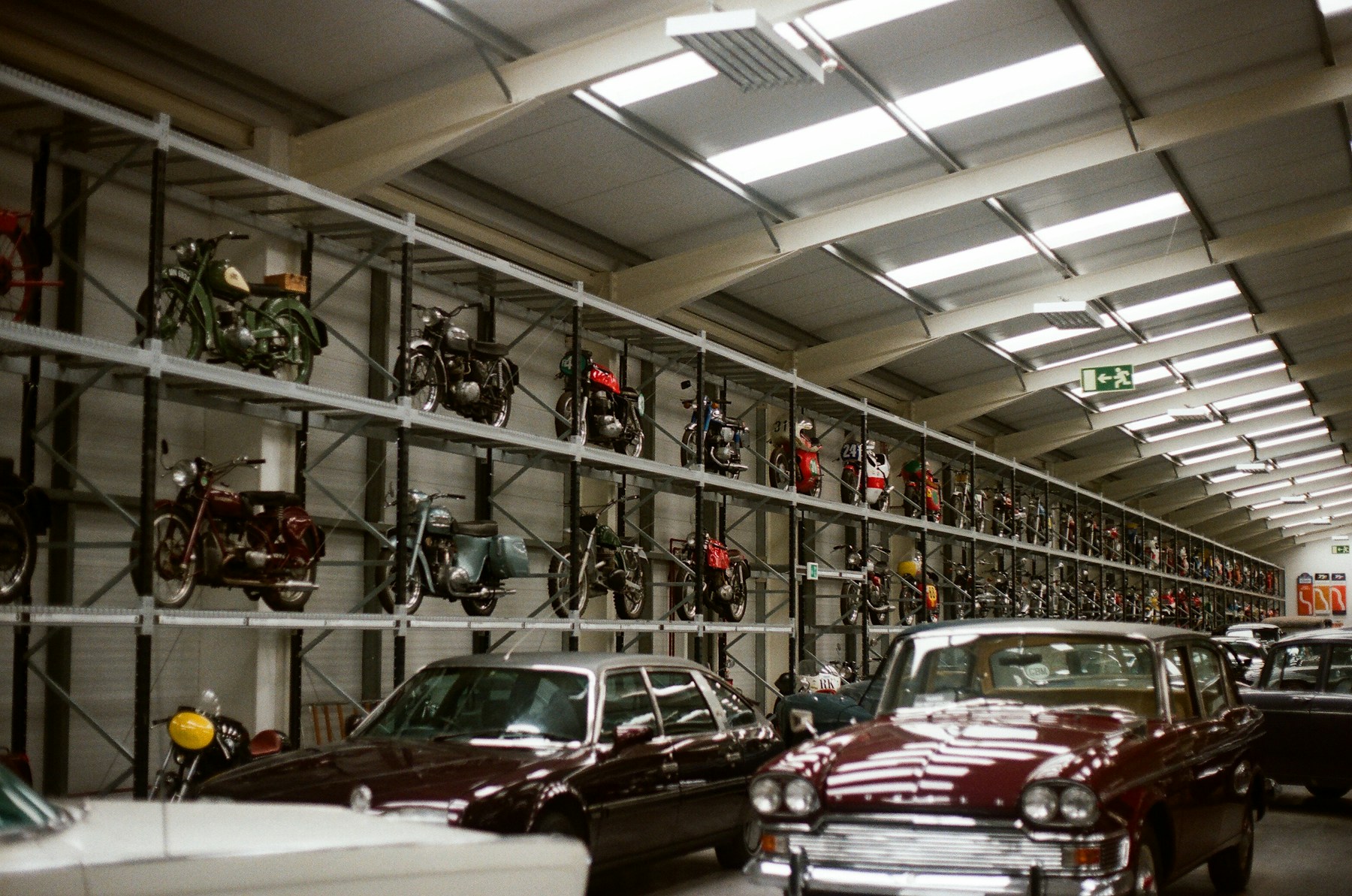 Interior of a private collector's garage with covered classics and warm uplighting.